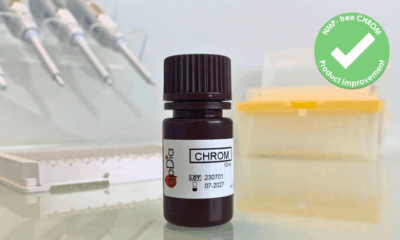 Close-up of an apDia CHROM Chromogen Solution bottle on a laboratory bench, with pipettes, a microplate, and laboratory containers blurred in the background. A green badge in the top right reads "NMP-free CHROM Product improvement" with a checkmark.